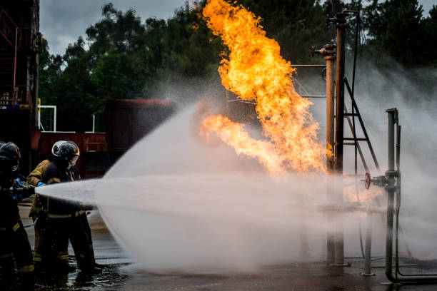 istock firefighters face the flames protected by water 1992753807