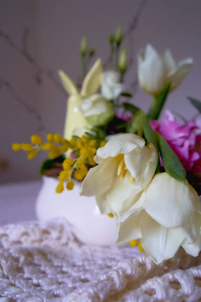 Easter flower arrangement with a ceramic rabbit in a minimalist style, gypsophila, rose, miss bombastic, avalanche, iris, tulip, eucalyptus, ceneria,