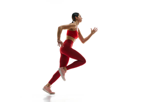 Dynamics, endurance and energy. Female runner athlete in motion, running, training against white studio background
