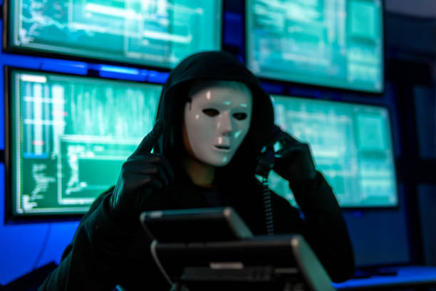 istock Wanted Hacker wearing a hoodie top and a Masked Face to hide his identity and using computer for hacking in the cyber data center 1992809987