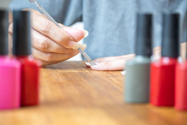 istock Woman using a cuticle pusher on her fingers. 1992812129