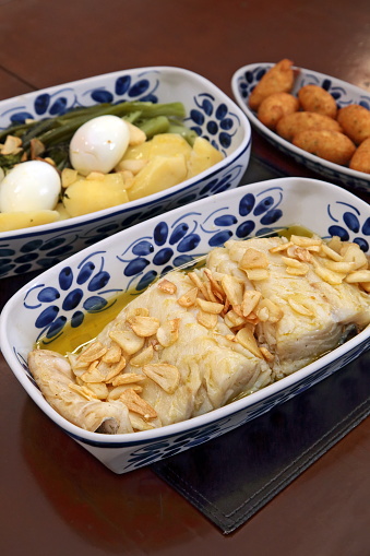 oven-baked cod with thin slices of garlic and olive oil. Served with broccoli, eggs and boiled potatoes