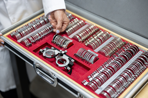 Close-up on an ophthalmologist using a phoropter at her office â healthcare and medicine concepts