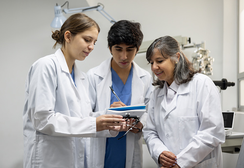 Latin American medical students learning about medica equipment at an ophthalmologist office - medical school concepts