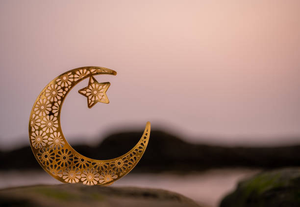 istock crescent moon shape on the beach, 2024 eid mubarak theme, golden moon,Half moon isolated on seascape background, 1992838796
