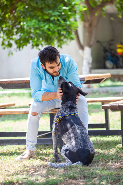 istock Young man having fun and playing with his dog in a park. 1992898850