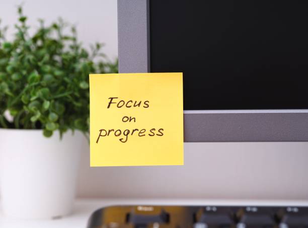 istock Yellow paper note with reminder Focus on Progress on it sticked on to a monitor 1992909491