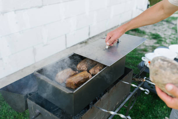 istock A man's hand opens a smokebox with lard in nature. Country dinner 1992923194