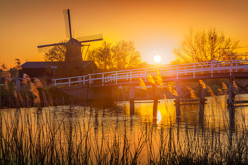 Famous mindmills in Kinderdijk museum in Holland, UNESCO World Heritage Site. Colorful spring sunset in countryside. Splendid outdoor scene in Netherlands, Europe. Artistic style post processed photo.