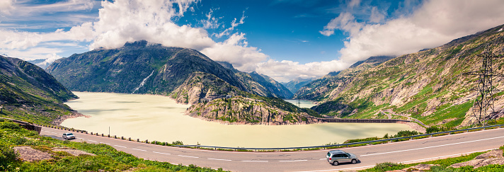 Sunny morning panorama of the coast of Grimselsee reservoir on the top of Grimselpass. Colorful summer in Swiss Alps,  canton of Bern in Switzerland, Europe. Artistic style post processed photo.