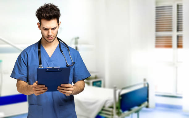 istock Male nurse reading a clipboard 1992937533