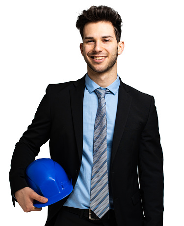 Upbeat young male engineer holding a blue hard hat, isolated on white