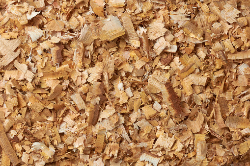 wood chips or shavings, small pieces of wood produced as a byproduct, shaved or chopped from larger pieces of wood, renewable and environmentally friendly resources, full frame background