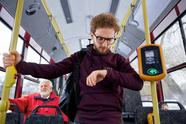 istock Young busy men with watch hurrying to work by bus 1993038902