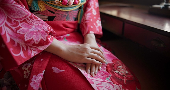 Closeup, hands together and Japanese woman with traditional clothes and praying with religion. Person, culture and routine with girl or home with outfit and peaceful with stress relief and meditation