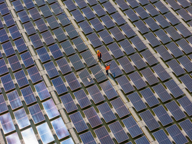 istock Worker Cleaning  floating solar panels or solar cell Platform system on the lake with brush and water. Worker cleaning solar modules in a Solar Energy Power Plant 1993112141