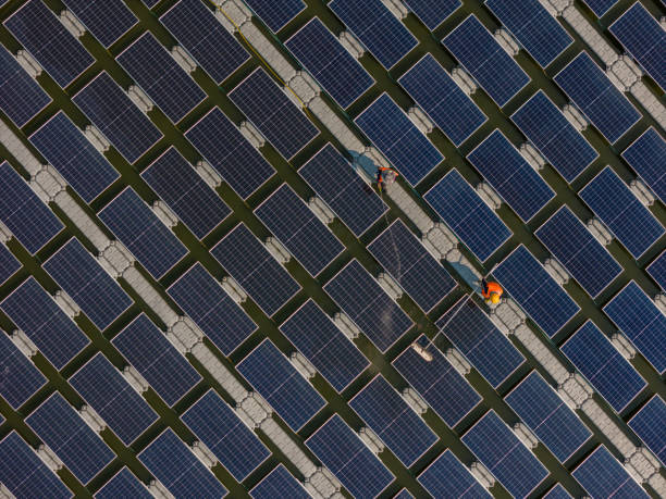 istock Worker Cleaning  floating solar panels or solar cell Platform system on the lake with brush and water. Worker cleaning solar modules in a Solar Energy Power Plant 1993113184