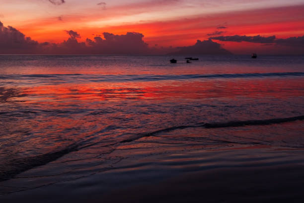 Ocean shore water under colorful sunset sky. Mahe island, Seychelles. Night beach landscape