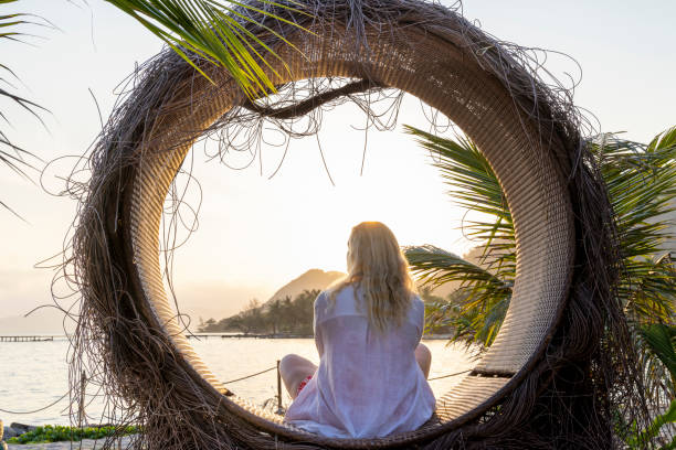 istock Mature woman relaxes in circle at water's edge 1993126798
