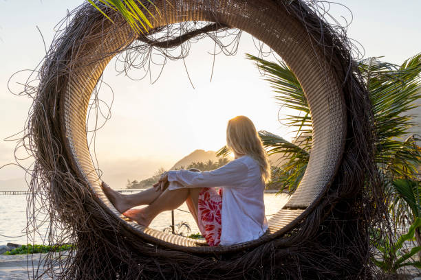 istock Mature woman relaxes in circle at water's edge 1993127830