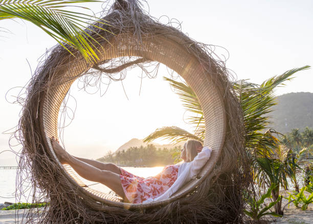 istock Mature woman relaxes in circle at water's edge 1993130413