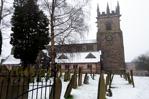 St Mary and All Saints Church in Chesterfield, England, with cars and people visible in the background