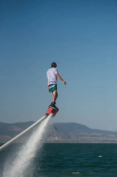 Photo of A man playing extreme fly board on the lake.