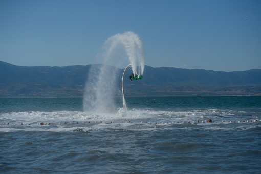 A man playing extreme fly board on the lake.