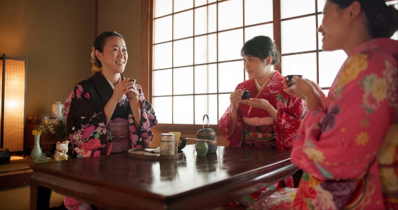 Japanese, women and matcha for tea ceremony in Chashitsu room with kimono dress or custom tradition. People, temae and vintage style outfit or drinking for culture, heritage and happy with pride