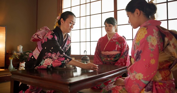 Japanese, women and kimono for tea ceremony in Chashitsu room with matcha or custom tradition. People, temae and vintage style outfit or dress for culture, heritage and happy with waiting and pride