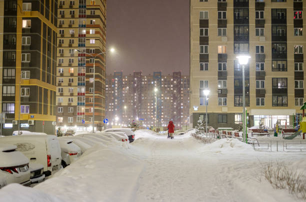 courtyard with new houses in a new building on a winter evening in snowfall