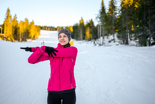 Active young woman stretching and doing exercises during the winter day
