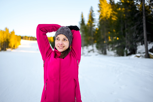 Active young woman stretching and doing exercises during the winter day