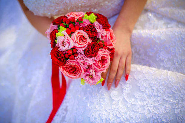 the hands of the bride and groom with wedding rings on a bouquet of flowers. The concept