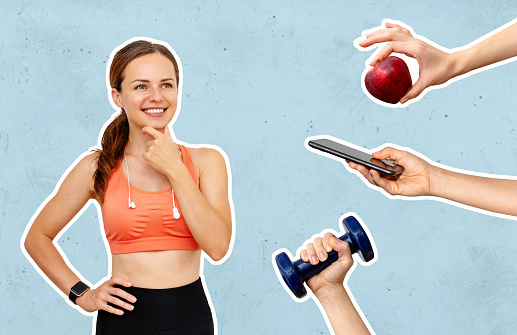 Conceptual background of sports mobile app, sports nutrition, and workouts. Female athlete and mobile phone, red apple, and dumbbell in hand.