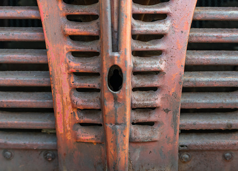 close up of an old red rusted car grill