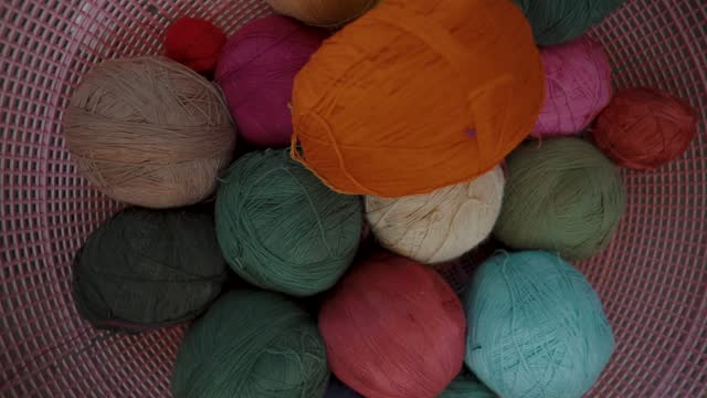 Weaving - Basket of Colorful Yarn Balls. - high angle, spin, descend shot