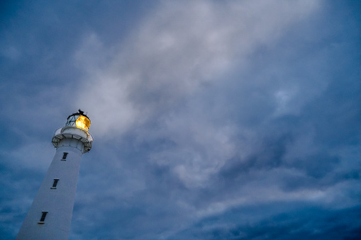 Lighthouse Beacon Shining Against a Stormy Sky - New Zealand Castelpoint