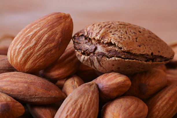 istock Beautiful background with raw almonds in brown shell; closeup photography 1993228934