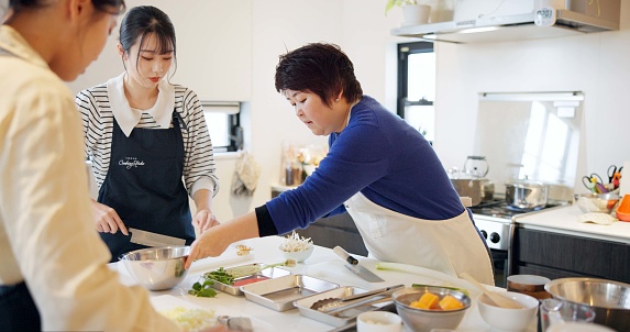 Japanese chef, women and cooking school with teaching, advice and knife for vegetables, ingredients or food. People, cuisine and fine dining in kitchen with coaching, support and knowledge in Tokyo
