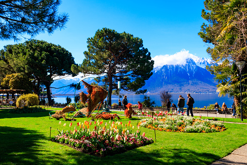 Montreux, Switzerland - April 10, 2022: Spring park with flowerbeds and sea animals grass sculptures at riviera of Lake Geneva in Montreux, Switzerland