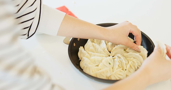 Japan, hands and dumplings on table for dinner, brunch and traditional meal in restaurant or cafe. Culture, gyozo and asian cuisine for nutrition, healthy diet and lunch with preparation or pastry