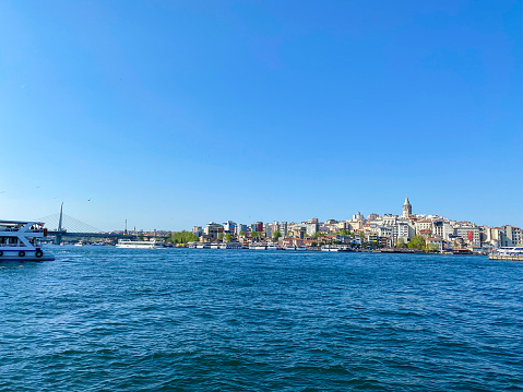 Galata tower view from Karakoy district with City lines ferry crossing the Galata bridge. Istanbul Turkey