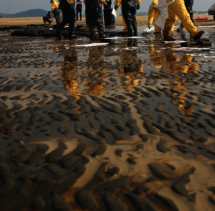 A crude oil spill on the sand of a city beach Beach oil spill impacts pollution waste disposal Ecological catastrophe.