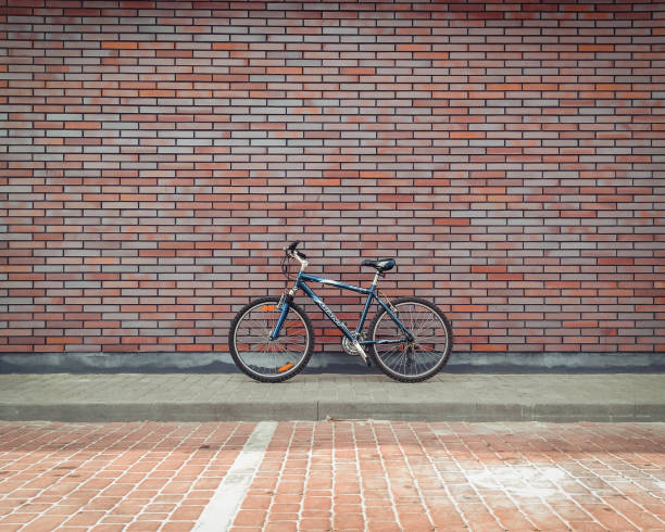 Kyiv, Ukraine - April 30 2015: blue bicycle near the brick wall. Side view of Giant bicycle leaning on the facade.
