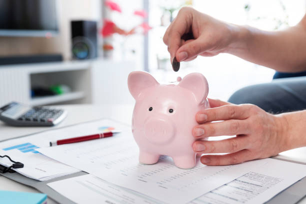 istock Savings concept with man putting coin 1993373275