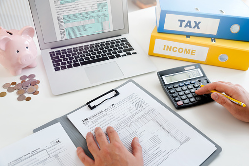 Tax time, tax concept with man filling tax form. Business income.