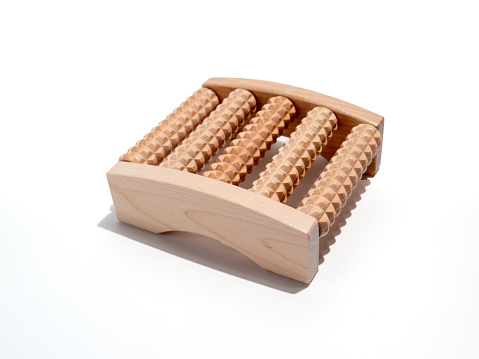 Wooden foot massager on a white background. Wooden massager close-up.