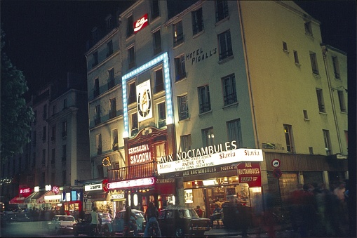 Pigalle, Paris, Il de France, France, 1973. Nightlife with tourists, locals, nightclubs, neon signs, bistros and vehicles on Boulevard de Clichy.