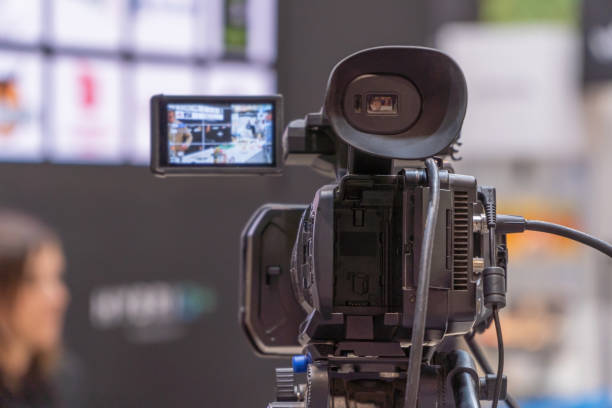 istock Professional TV Camera Setup Streaming Live Event From a Bustling Expo Hall 1993439275